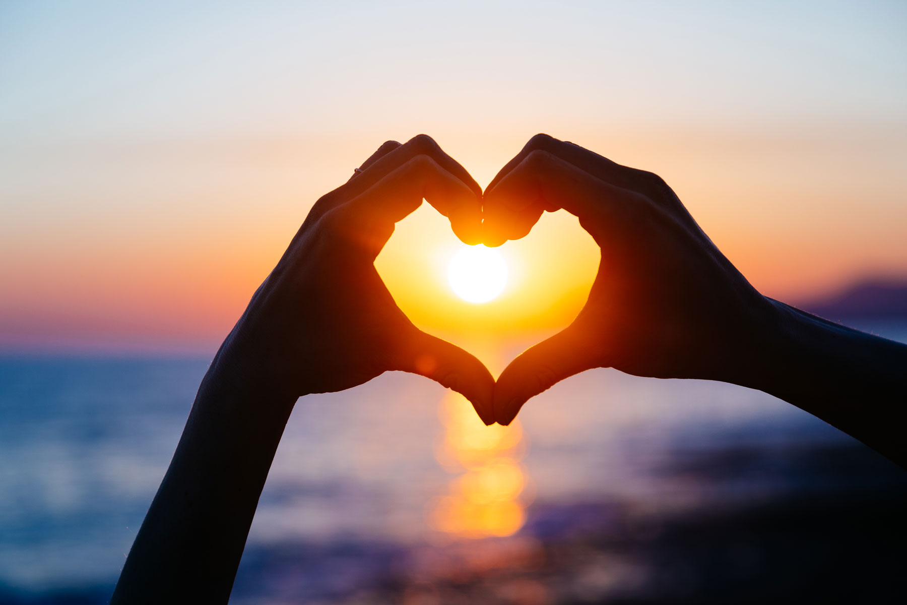 hands-forming-a-heart-shape-with-sunset-silhouette-636379014_5472x3648